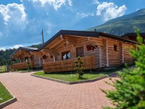 a log cabin with a driveway in front of it at Cabanele Petran in Borşa
