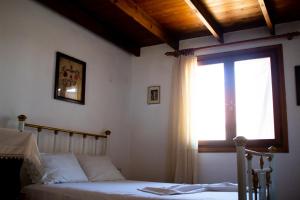 a bedroom with a bed and a window at Agrampeli in Limenaria