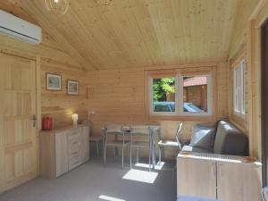 een kamer met een tafel en stoelen in een hut bij Domek mazurski ze świerka syberyjskiego. in Zdory