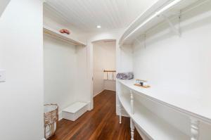 a hallway with white walls and wood flooring and a staircase at The Sanctuary:Downtown Staunton in Staunton +20 photos