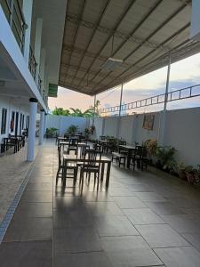 a patio with tables and chairs in a building at RedDoorz Buena's Pension in Puerto Princesa City