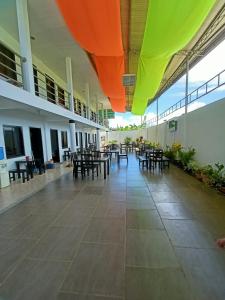 a cafeteria with tables and chairs in a building at RedDoorz Buena's Pension in Puerto Princesa City