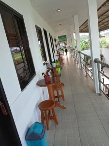 a balcony with tables and chairs on a building at RedDoorz Buena's Pension in Puerto Princesa City