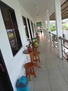 a balcony with tables and chairs on a building at RedDoorz at Buena's Pension Palawan in Puerto Princesa City
