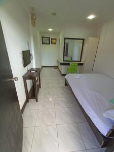 a bedroom with a bed and a table and a mirror at RedDoorz Buena's Pension in Puerto Princesa City