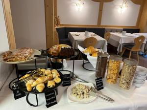 a table topped with different types of bread and pastries at Garnì Villa Elsa in Pozza di Fassa