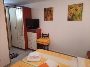 a bedroom with a bed and a tv and a table at Apartments Zlosilo in Orasac