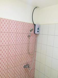 a shower in a bathroom with pink and white tiles at RedDoorz at Buena's Pension Palawan in Puerto Princesa City