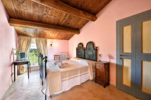 a bedroom with a bed and a wooden ceiling at Villa Collepere Country House in Matelica