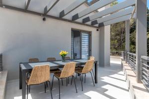 a patio with a black table and chairs at Villa Pinia Fazana in Fažana
