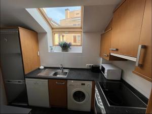 a small kitchen with a sink and a washing machine at Ático Guara&Pirineos in Huesca