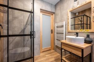 a bathroom with a sink and a mirror at Pokoje Gościnne Maryniarczyk in Kościelisko