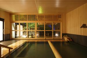 a swimming pool in a house with a large window at Negiya Ryofukaku in Kobe