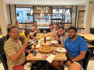 a group of people sitting around a table eating food at Mango Tree Homestay & Ijen Tour in Banyuwangi