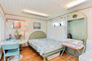 a small bedroom with a bed and a table at Undinėlė in Šventoji
