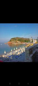 a beach with chairs and umbrellas on the water at Anika in Sutomore