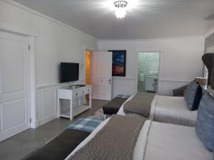 a living room with two beds and a television at Linda se Dop in Nieuwoudtville