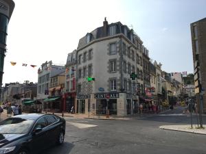 samochód zaparkowany przed budynkiem przy ulicy miejskiej w obiekcie Appartement calme en plein centre ville w mieście Granville +1 zdjęcie