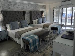 a bedroom with two beds and a brick wall at Linda se Dop in Nieuwoudtville +104 photos