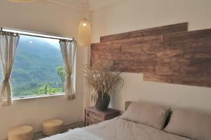 ein Schlafzimmer mit einem Bett und einem großen Fenster in der Unterkunft Pavi home in Sa Pa
