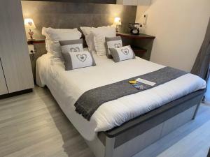 a bedroom with a large bed with pillows on it at Hôtel Le Méditerranée in Hyères