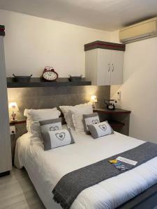 a bedroom with a large bed with two pillows at Hôtel Le Méditerranée in Hyères