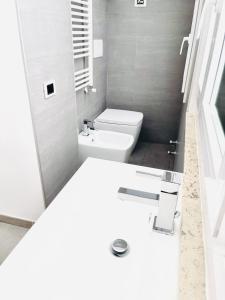 bagno bianco con servizi igienici e lavandino di Apartment Sigaba a Milano