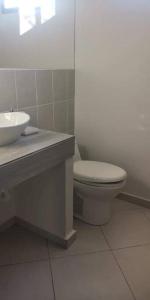 a bathroom with a white toilet and a sink at Casa llena de naturaleza y paz perfecta para descansar. in San Miguel
