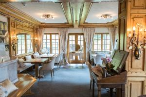 a dining room with tables and chairs and windows at Pfefferkorn's Hotel in Lech am Arlberg