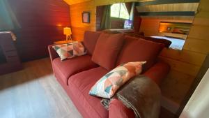 a living room with a red couch with pillows at Domaine Vallon des Ocres in Bonnieux