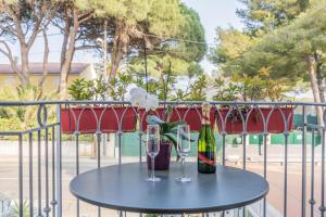 een tafel met twee glazen en een fles wijn bij Hôtel Le Méditerranée in Hyères