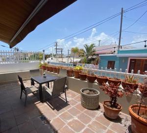 un patio con mesa, sillas y macetas en KASA Charming Luna 2 bedroom, en San Juan