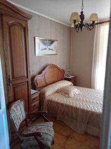 1 dormitorio con 1 cama y 1 silla en CASA DO RIZAL en Lagoa