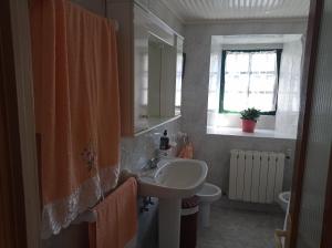 baño con lavabo y aseo y ventana en CASA DO RIZAL en Lagoa