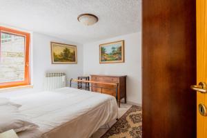 a bedroom with a bed and a dresser and a window at Palazzina Bucaneve in Pontagna