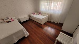 a small room with two beds and a window at Casa del Patio in Cangas de Morrazo