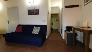 salon z niebieską kanapą i korytarzem w obiekcie Oliviera Camere w mieście Pienza