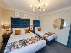 a hotel room with two beds and a mirror at Hotel Collingwood BW Signature Collection in Bournemouth