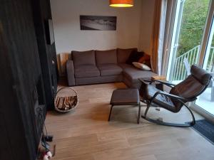 a living room with a couch and a chair at Maison chaleureuse et lumineuse à 400m de la plage in Veulettes-sur-Mer