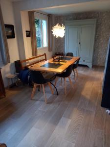 a dining room with a wooden table and chairs at Maison chaleureuse et lumineuse à 400m de la plage in Veulettes-sur-Mer