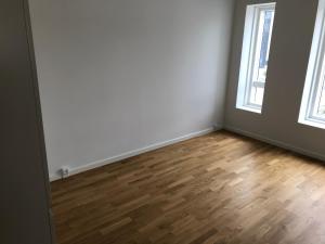 an empty room with a wooden floor and two windows at Big Room In SHARED APARTMENT With King Size Bed in Copenhagen