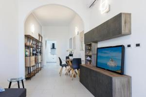 Una sala de estar con un televisor en la pared. en Antonia Suite, en Cagliari