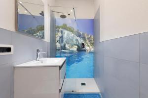 baño con una pintura de una cascada en la pared en Antonia Suite, en Cagliari 14 fotos más