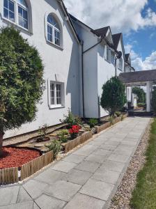 a white house with a sidewalk in front of it at DAGMARA in Łeba
