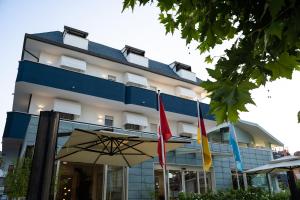 a building with three flags in front of it at Hotel Mare Blu in Francavilla al Mare