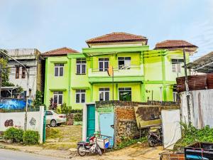a yellow and green house in front of a street at SPOT ON 91325 Pondok Hijau Guest House Syariah in Cilimus 2