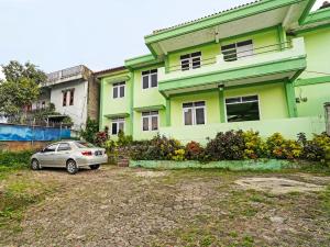 a car parked in front of a green building at SPOT ON 91325 Pondok Hijau Guest House Syariah in Cilimus 2