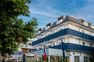 a blue and white building with flags in front of it at Hotel Mare Blu in Francavilla al Mare