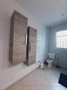 a bathroom with a toilet and a large wooden partition at Charmante demeure au cœur de la provence verte in Bras