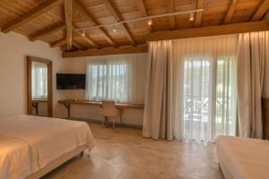 a bedroom with a bed and a desk and a window at Liadromia Hotel in Patitiri